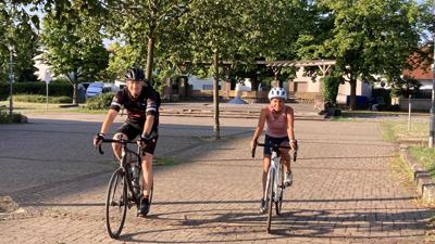Zwei Fahrradfahrer auf dem Rathausvorplatz Ötigheim.