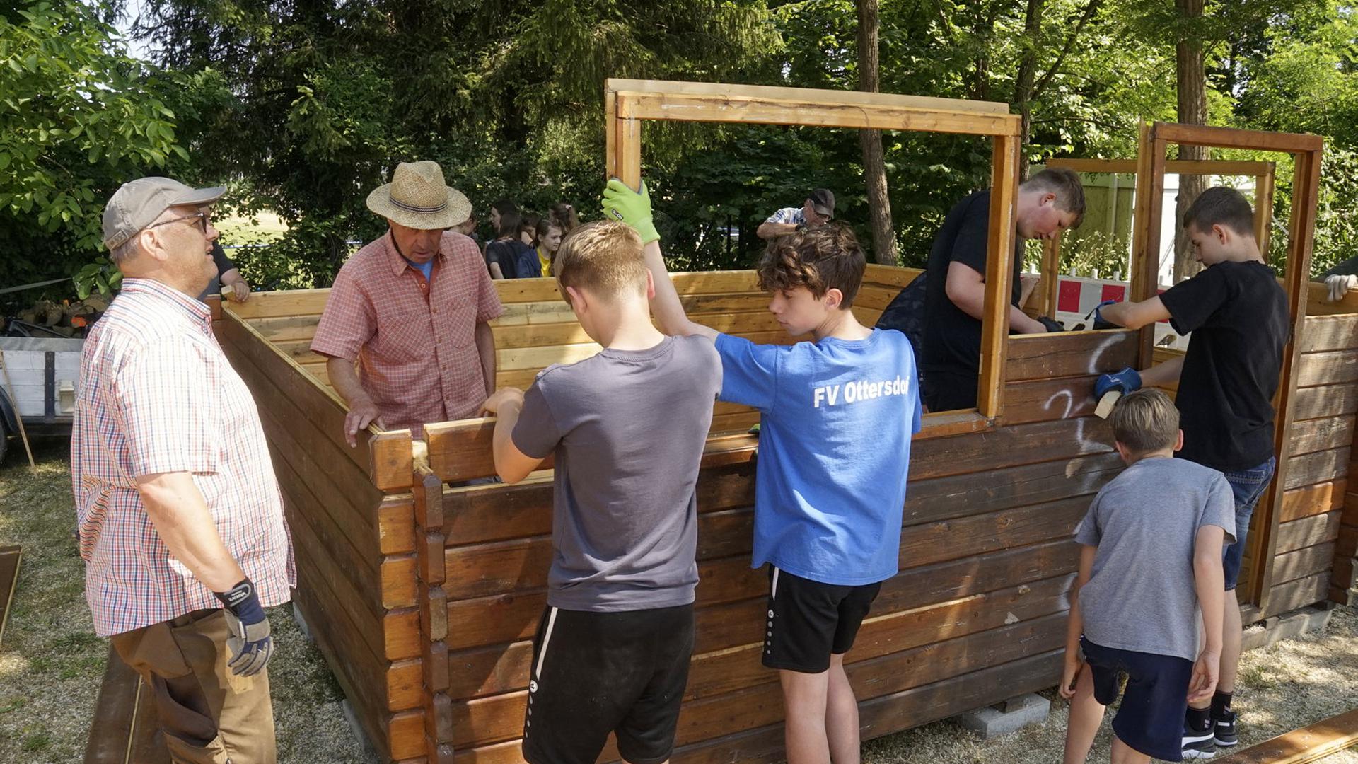 Ottersdorfer Jugendliche, vier Rentner und der Ortsvorsteher bauen die Holzhütte am Oberwald auf.                               