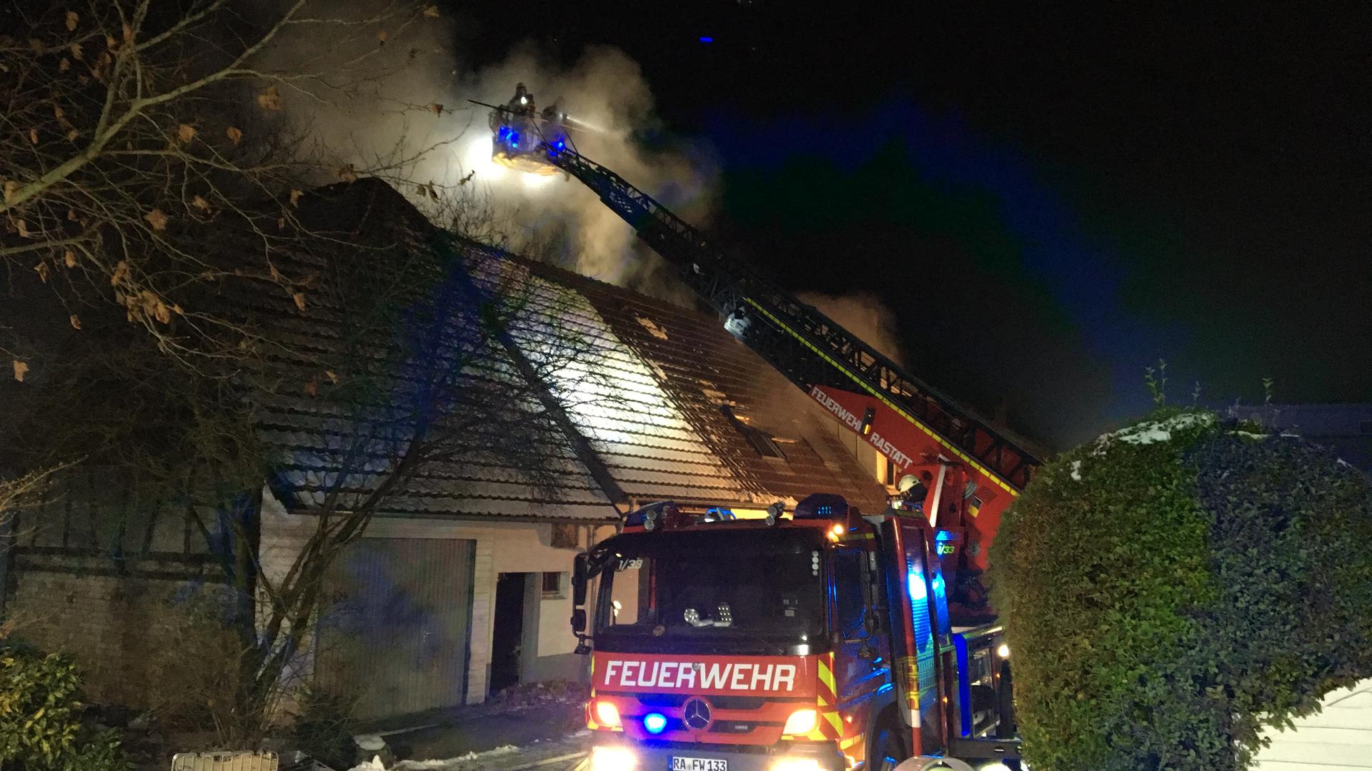 Feuerwehrleute löschen ein brennendes Haus