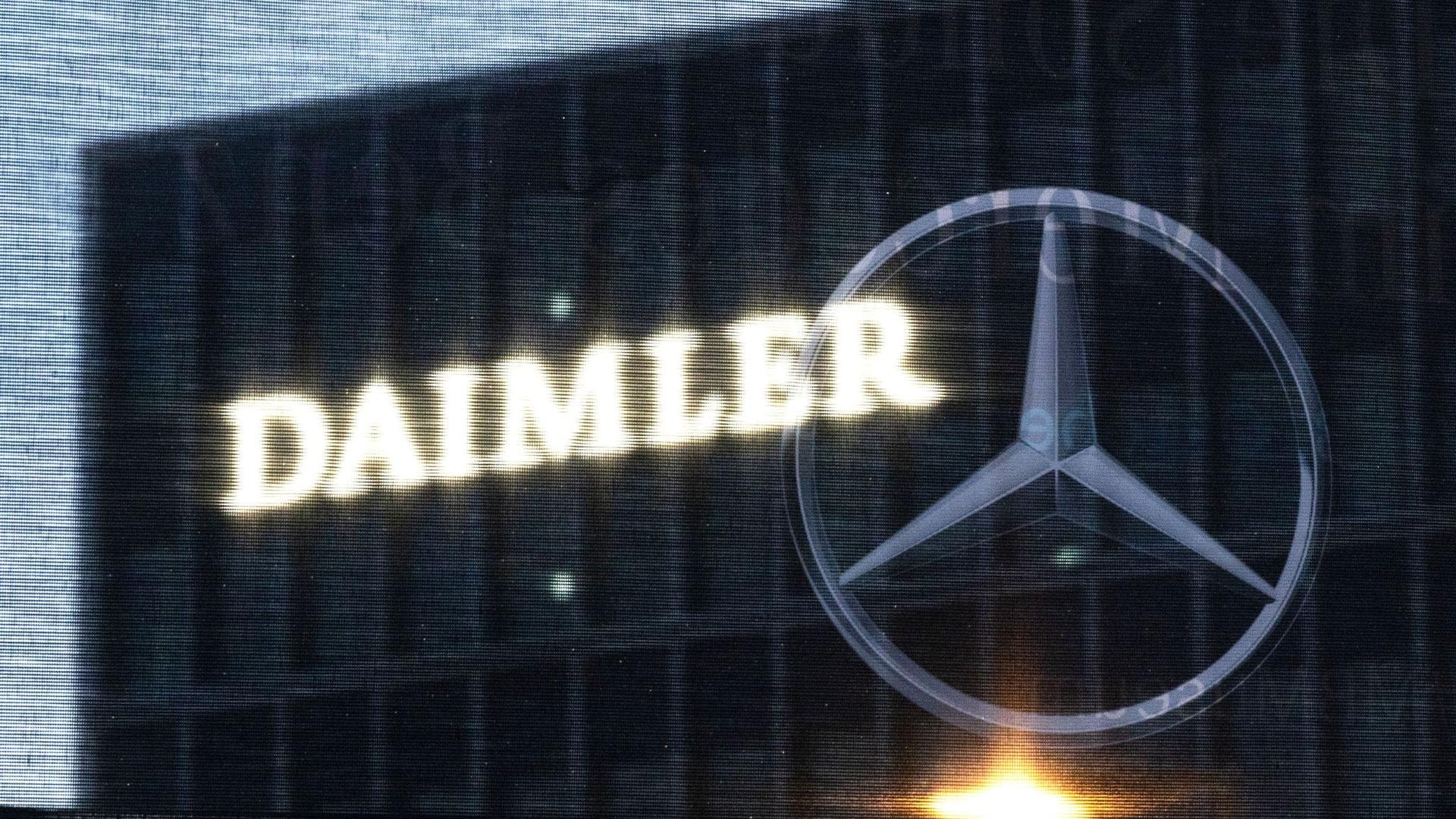 Die Zentrale der Daimler AG ist durch eine Flagge zu sehen, auf der der Mercedes-Stern abgebildet ist.