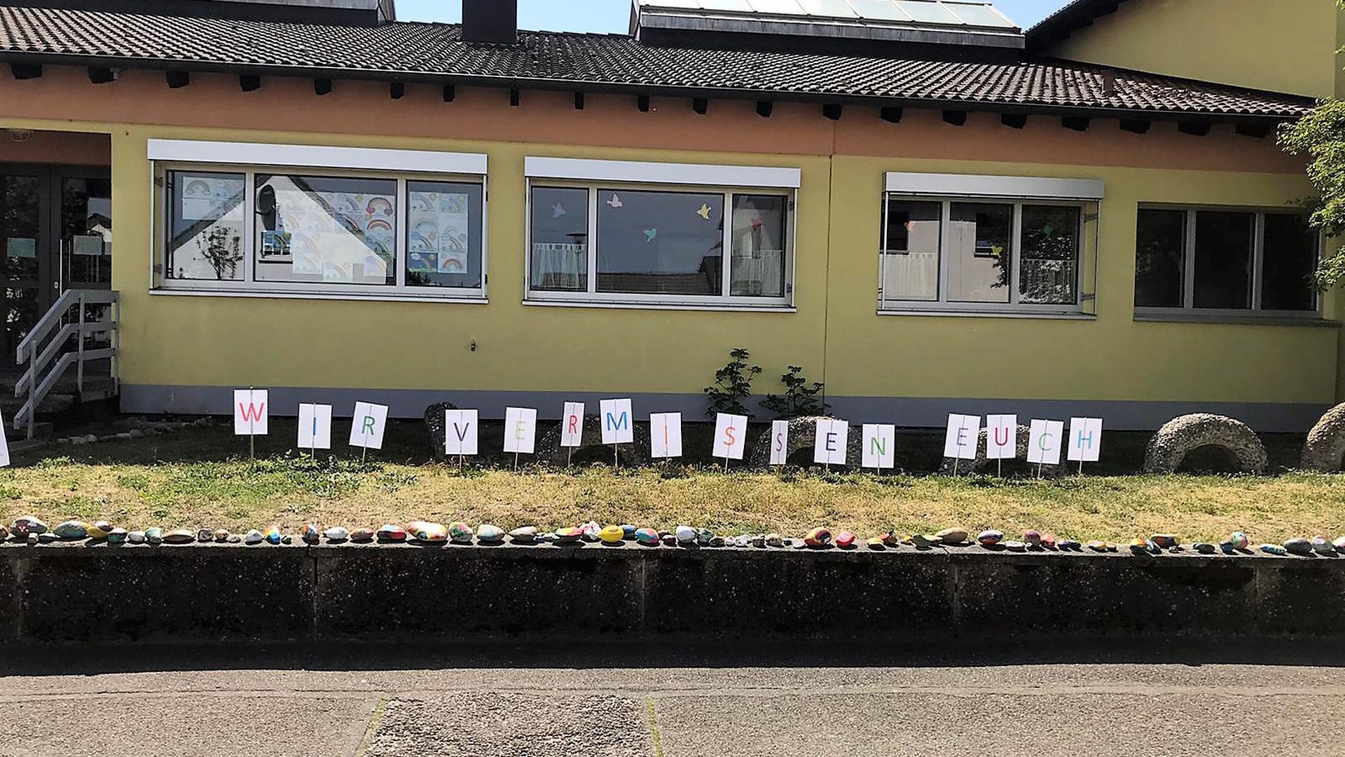 „Wir vermissen Euch“: Das wollen die Erzieherinnen aus dem Kindergarten St. Martin in Iffezheim den Kindern mit den einlaminierten Buchstaben auf dem Rasen vor der Einrichtung zeigen.