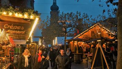 Menschen laufen an den Buden vorbei über den Weihnachtsmarkt in Rastatt.