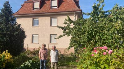 Zwei Männer im Garten vor einem Haus