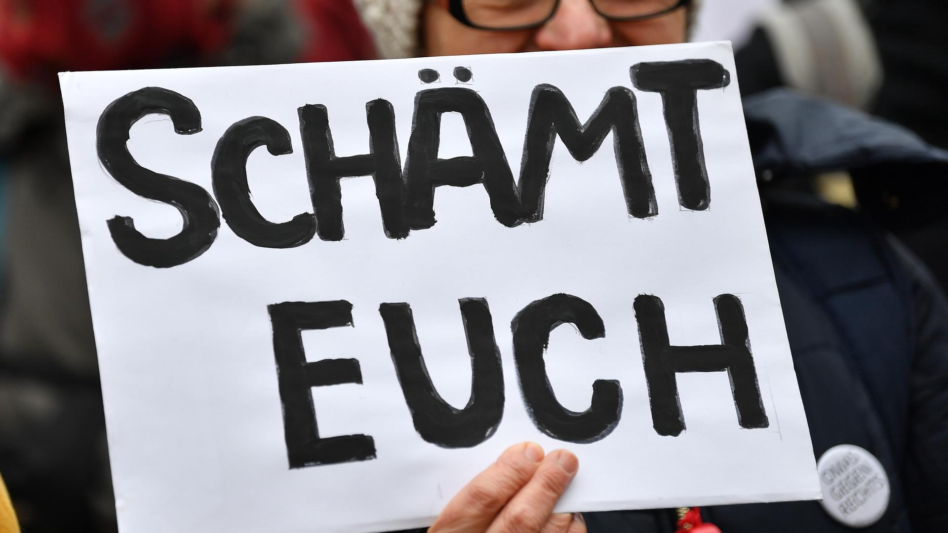 Eine Frau mit einem Schild "Schämt euch" demonstriert gegen die Wahl Kemmerichs zum Ministerpräsidenten von Thüringen. Der FDP-Kandidat Kemmerich war am 05.02.2020 im Thüringer Landtag überraschend mit den Stimmen von Liberalen, CDU und AfD zum Regierungschef gewählt worden. +++ dpa-Bildfunk +++
