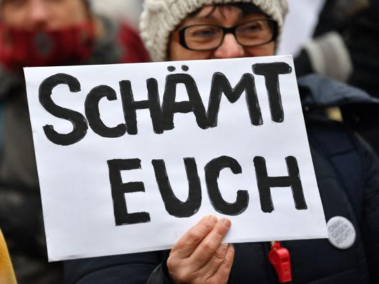 Eine Frau mit einem Schild "Schämt euch" demonstriert gegen die Wahl Kemmerichs zum Ministerpräsidenten von Thüringen. Der FDP-Kandidat Kemmerich war am 05.02.2020 im Thüringer Landtag überraschend mit den Stimmen von Liberalen, CDU und AfD zum Regierungschef gewählt worden. +++ dpa-Bildfunk +++