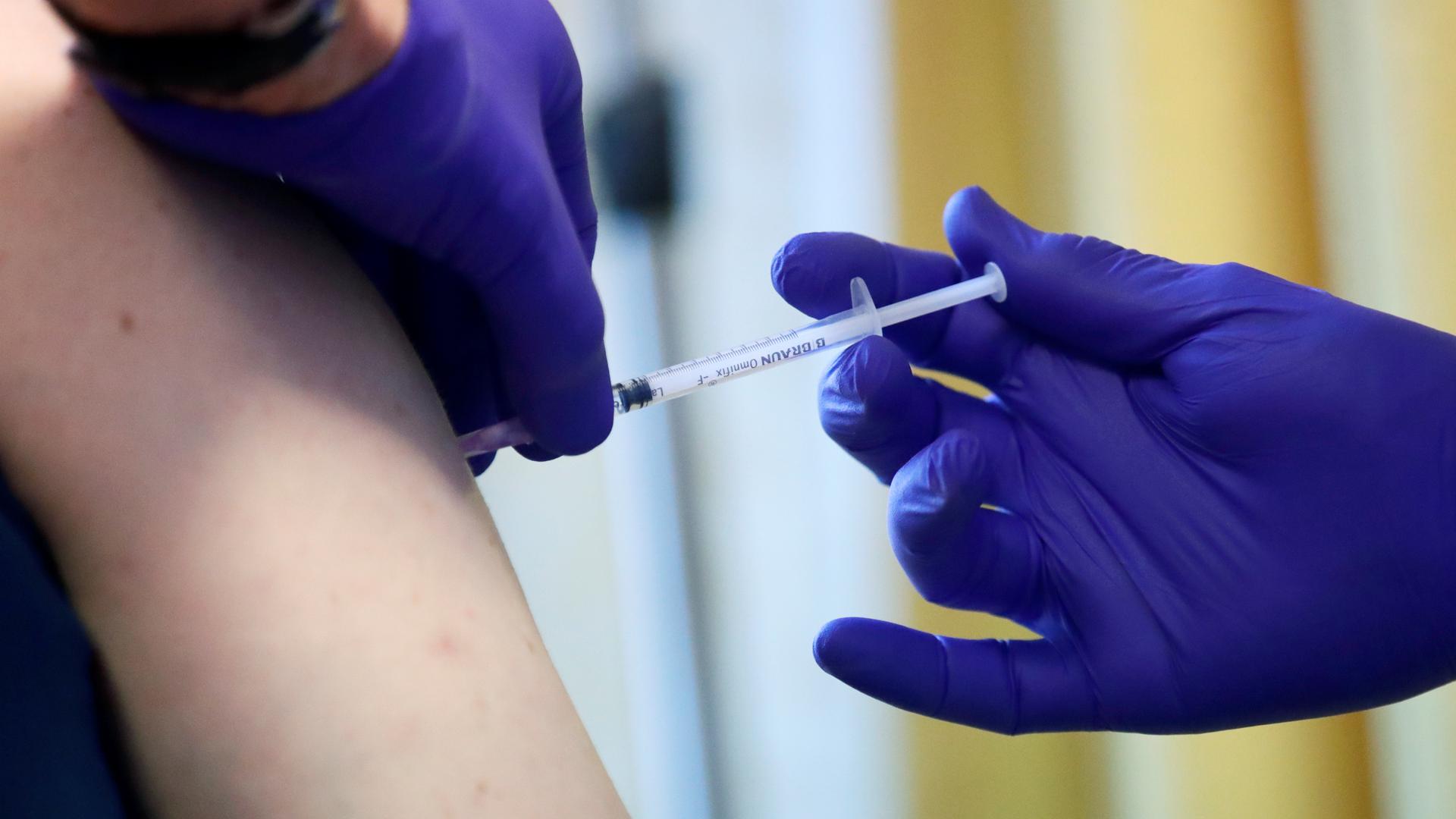 Ein Patient erhält beim offiziellen Start der Corona-Impfungen in Arztpraxen in der Praxis von Dr. Carganico seine Impfung.