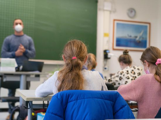 Schülerinnen und Schüler der Klasse 5c des Matthias-Grünewald-Gymnasiums in Würzburg sitzen mit Mund-Nasen-Schutz im Klassenzimmer. In Bayern beginnt die Schule nach den Herbstferien mit neuen Corona-Regeln. +++ dpa-Bildfunk +++