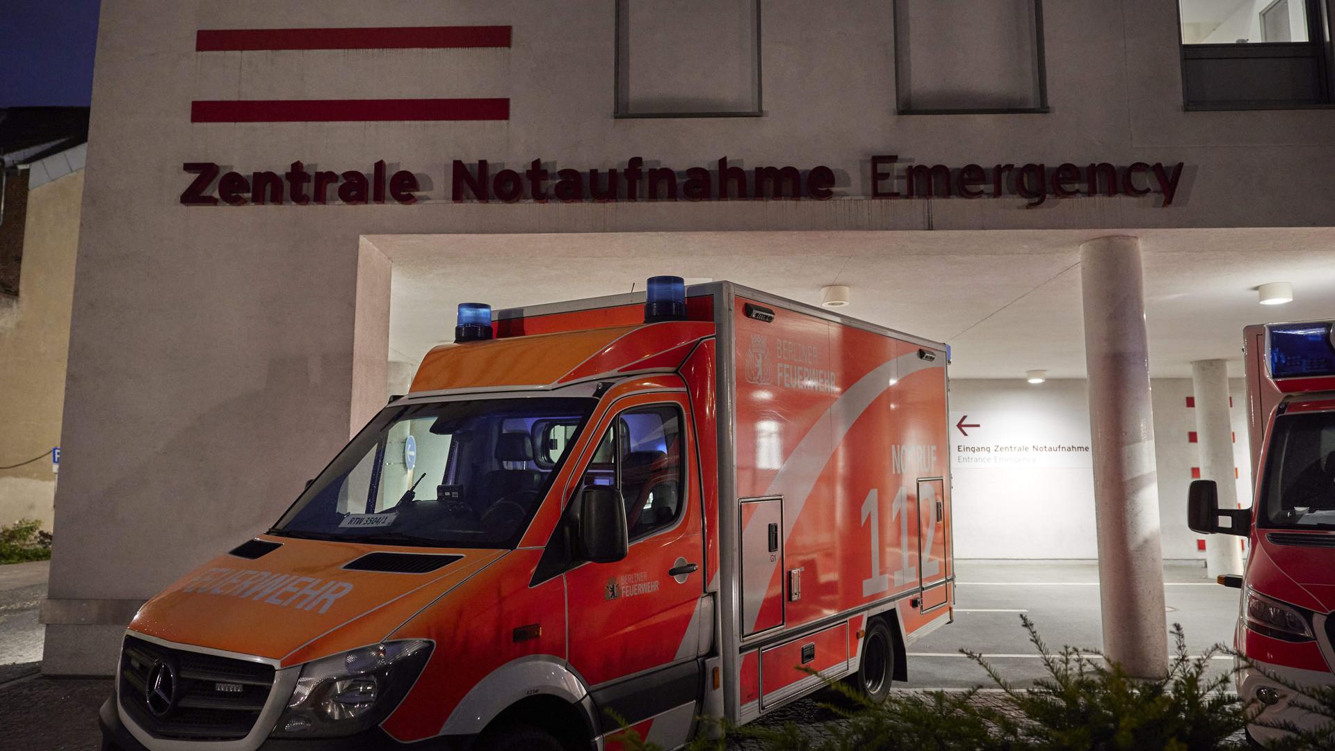 Ein Schriftzug der Zentralen Notaufnahme ist an einem Gebäude der Berliner Charité – Universitätsmedizin zu sehen, während davor ein Rettungswagen steht. 