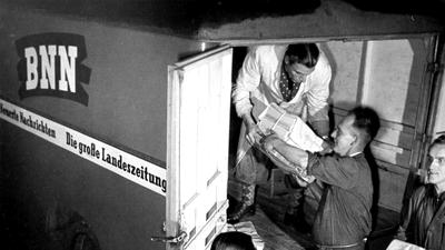 Männer beladen 1953 ein BNN-Fahrzeug mit Zeitungen.