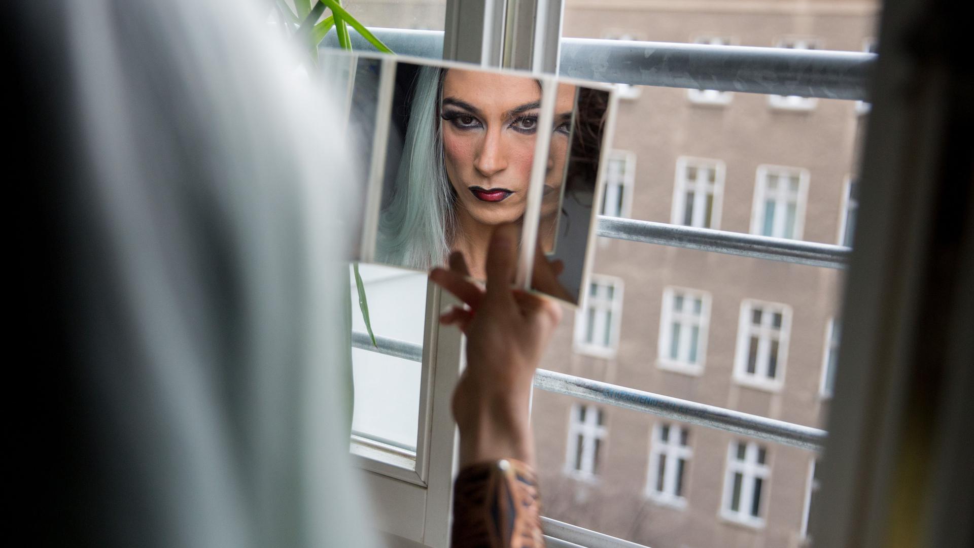 Julian Fricker, alias Drag Queen Shiaz Legz, blickt am 04.04.2016 in Berlin in einen Spiegel. Foto: Kay Nietfeld/dpa (zu dpa-story «Wer einen Penis hat, ist nicht automatisch ein Mann» vom 16.08.2016) - Name berichtigt ++ +++ dpa-Bildfunk +++