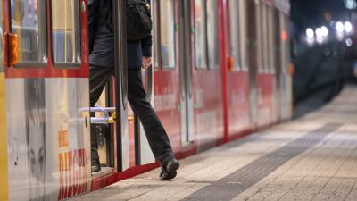 Ein Mann steigt im morgendlichen Berufsverkehr in eine U-Bahn.