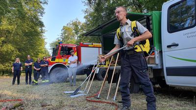 Mit Löschrucksack und Spritze: Lukas Stange vom Landesbetrieb ForstBW ist Waldbrandbeauftragter im Forstbezirk Hardtwald. Er demonstriert eine Zusatzausstattung für die Pritschenwagen der Waldarbeiter. Damit können Brandherde in Schach gehalten werden, bis die Feuerwehr eintrifft.