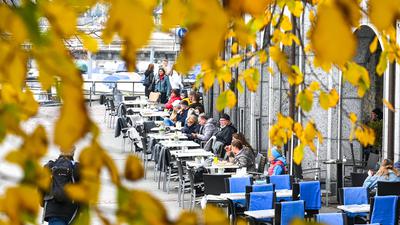 Gäste sitzen am Ufer des Bodensees bei rund neun Grad Celsius in einem Café.