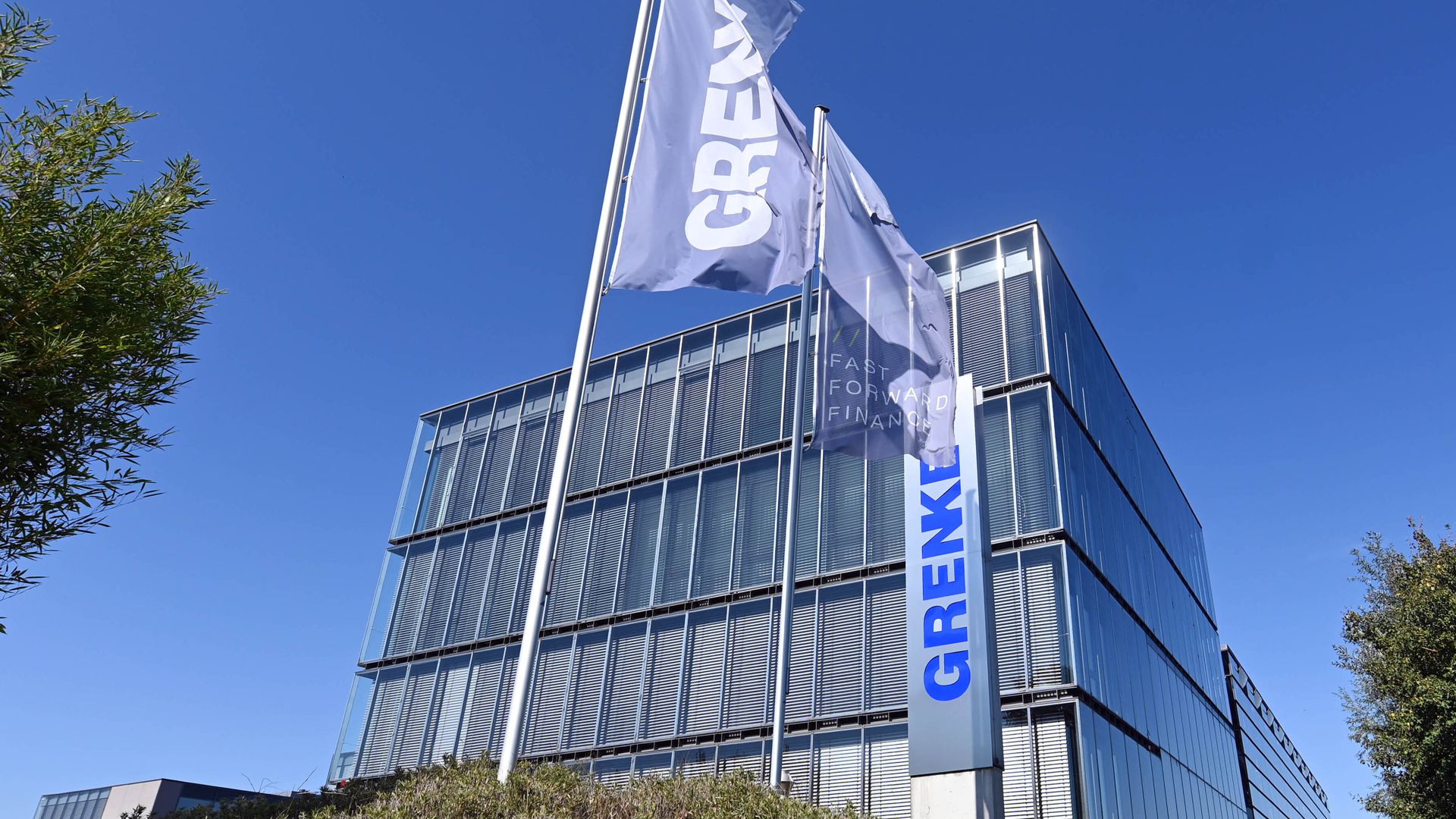 Flaggen mit dem Schriftzug des Finanzdienstleisters Grenke AG wehen an der Zentrale des Unternehmens in Baden-Baden.