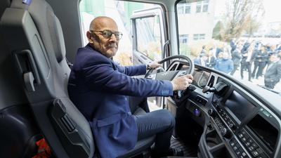 Winfried Hermann sitzt am Lenkrad im Führerhaus eines neuen LKW mit Wasserstoff-Antrieb.