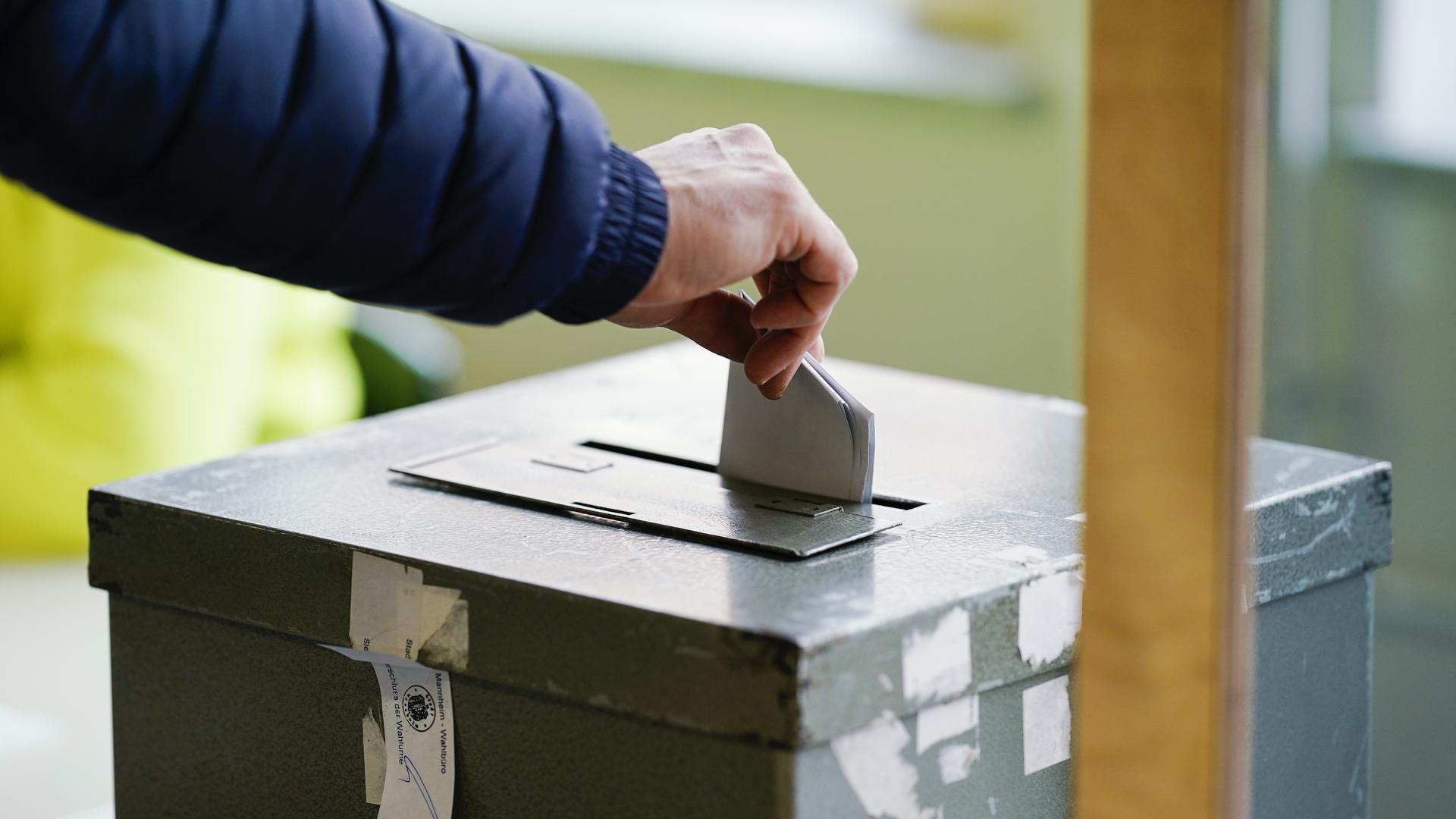 Ein Wählerin wirft in einem Wahllokal ihren Stimmzettel in die Wahlurne. Bürgerinnen und Bürger in Baden-Württemberg sind zur Wahl eines neuen Landtages aufgerufen.