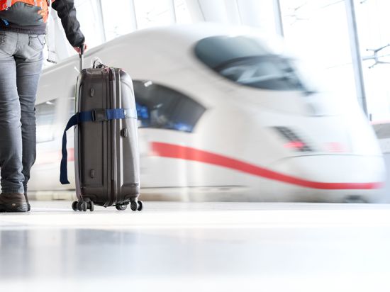 Ein Reisender mit Koffer steht vor einem ICE. (zu dpa: "Zug schlägt Auto und Flugzeug weiter beim klimafreundlichen Reisen",  SPERRFRIST MITTWOCH (24.3.) 0.01 MEZ BEACHTEN) +++ dpa-Bildfunk +++