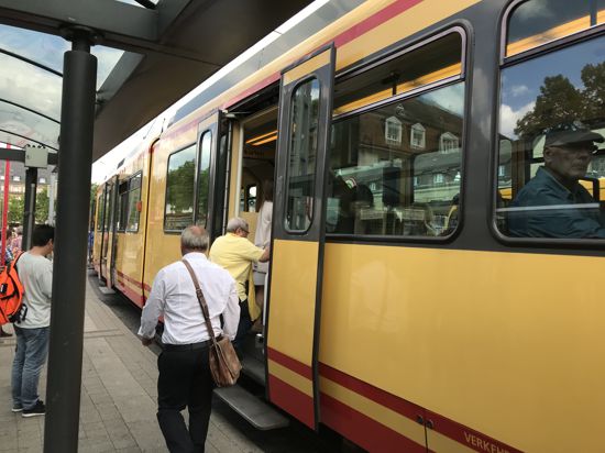 Menschen steigen in einer Straßenbahn des Karlsruher Verkehrsverbundes ein.
