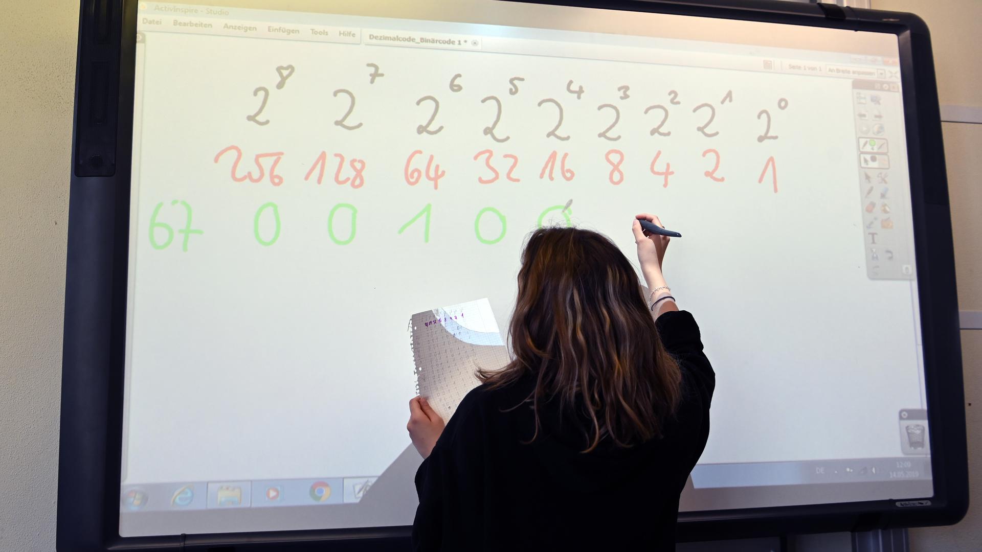 Eine Realschülerin einer zehnten Klasse arbeitet in einer Unterrichtsstunde an einem Active Board (interaktive Tafel).