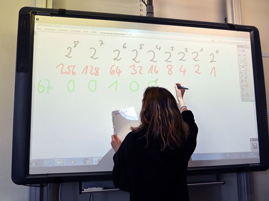 Eine Realschülerin einer zehnten Klasse arbeitet in einer Unterrichtsstunde an einem Active Board (interaktive Tafel).