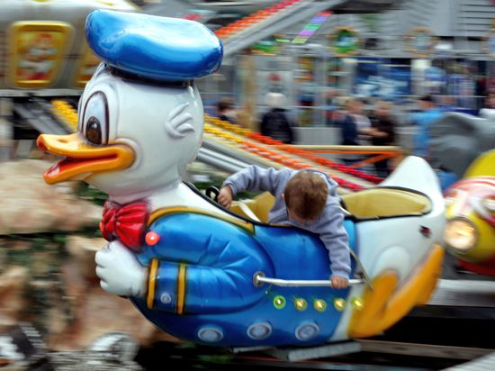 Kinderkarussell im Donald Duck Motiv mit einem Kind darin.