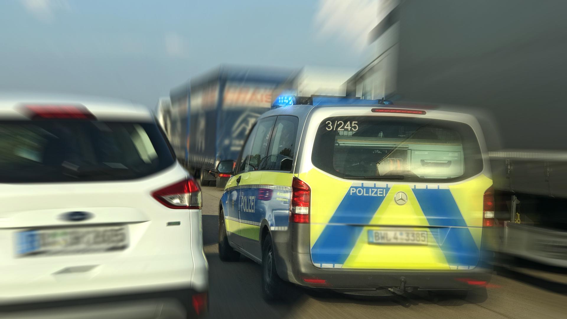 Ein Fahrzeug der Polizei passiert im Einsatz die Rettungsgasse zwischen zwei Fahrbahnen (Symbolbild)