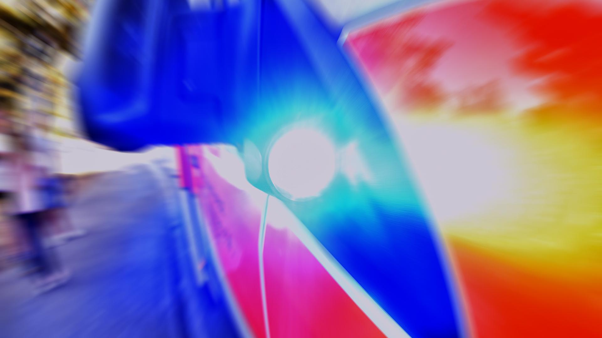 Unter dem Außenspiegel eines Rettungswagen strahlt das signifikante Blaulicht (Symbolbild)