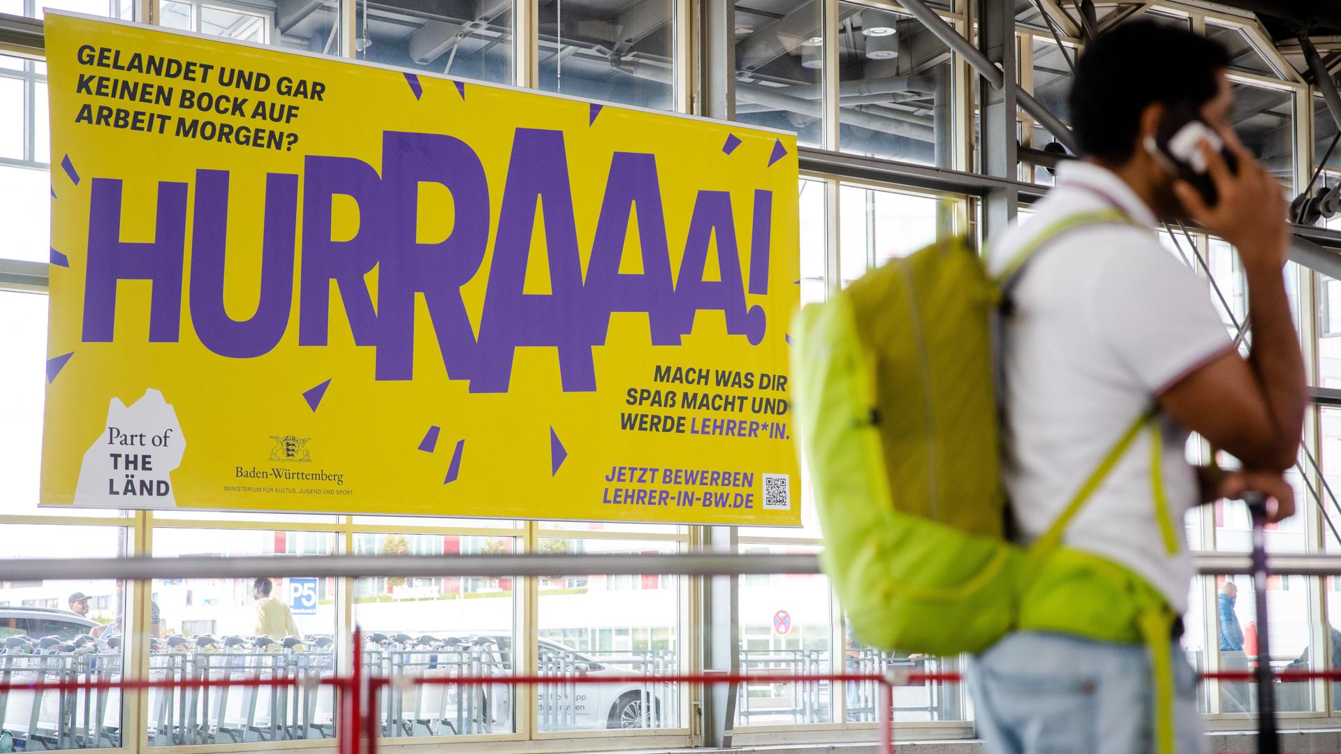 Ein Werbeplakat für den Beruf des Lehrers hängt am Flughafen in Stuttgart. Die Landesvorsitzende des Realschullehrerverbandes in Baden-Württemberg hält das Plakat für unangemessen. (Zu dpa "«Keinen Bock auf Arbeit morgen?» - Lehrer empört über Werbekampagne") +++ dpa-Bildfunk +++