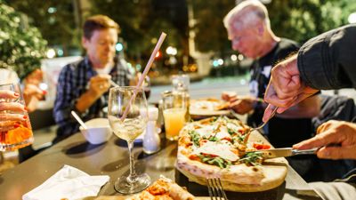 Menschen sitzen im Außenbereich eines Restaurants in der Innenstadt. Wirtschaftsforscher rechnen mit Steuerausfällen in Milliardenhöhe bei einer dauerhaft verringerten Mehrwertsteuer für Speisen in Restaurants. 