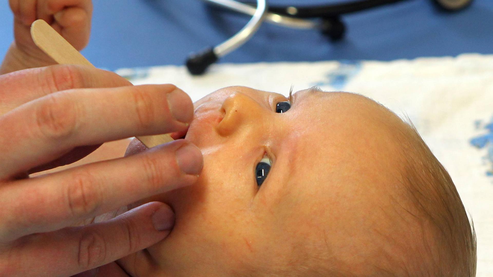 Ein Kinderarzt macht in seiner Praxis bei einem sechs Wochen alten Jungen eine U3-Vorsorgeuntersuchung. 