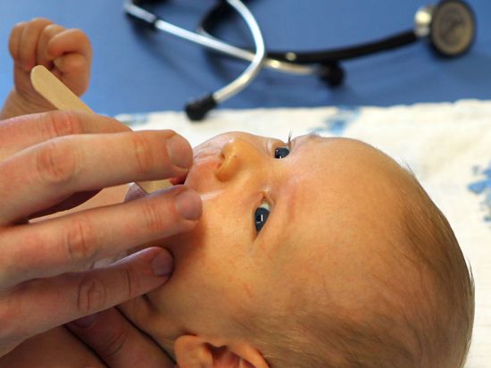 Ein Kinderarzt macht in seiner Praxis bei einem sechs Wochen alten Jungen eine U3-Vorsorgeuntersuchung. 