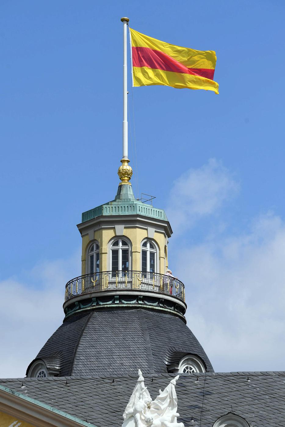11.07.2018, Baden-Württemberg, Karlsruhe: Auf dem Schloss Karlsruhe weht die badische Flagge. Nachdem der Ministerpräsident von Baden-Württemberg am Dienstag eine Ausnahme von der Landesverordnung zugelassen hat, ist es für das Badische Landesmuseum wieder möglich gewesen die Flagge zu hissen. Foto: Uli Deck/dpa +++ dpa-Bildfunk +++