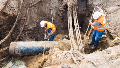 Bauarbeiter reparieren eine kaputte Wasserleitung. 