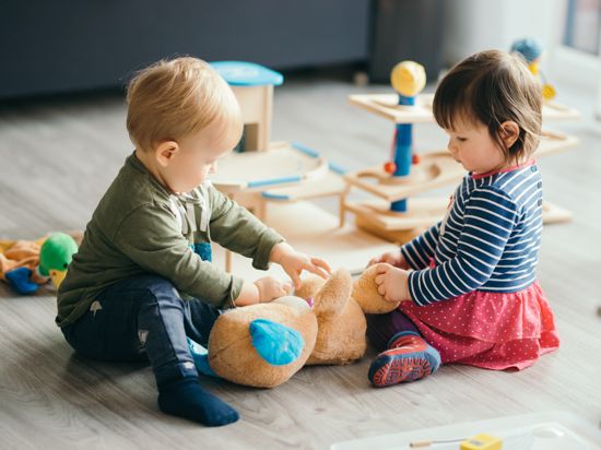 cute little girl and boy playing with toys by the home