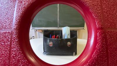 Die Aktentasche eines Lehrers auf dem Lehrertisch