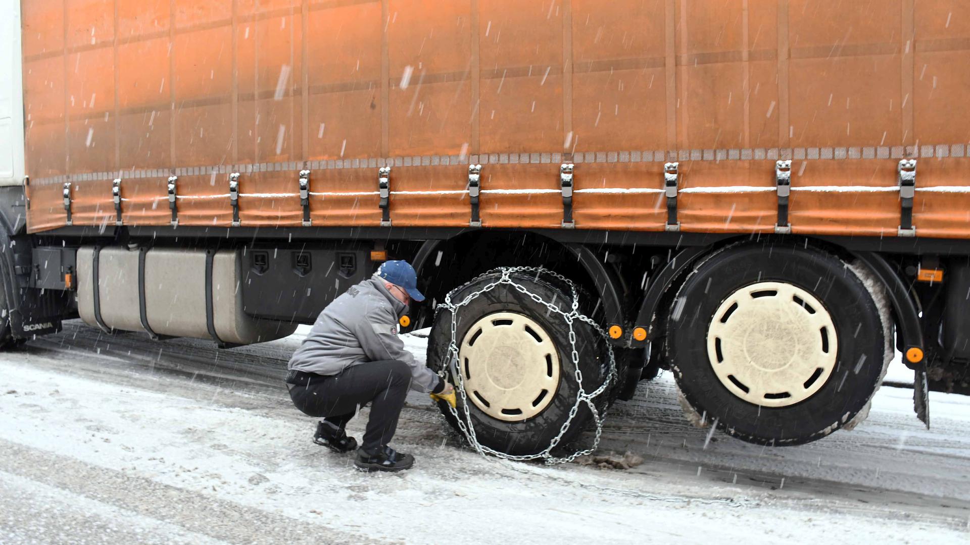 Ohne Schneeketten ging es nicht mehr: Dieser Lkw-Fahrer rüstet sein Fahrzeug oberhalb von Bühlertal für die Fahrt über Eis und Schnee nach. 