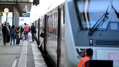 Reisende gehen an einem Bahnsteig auf dem Stuttgarter Hauptbahnhof zu ihrem Zug. +++ dpa-Bildfunk +++