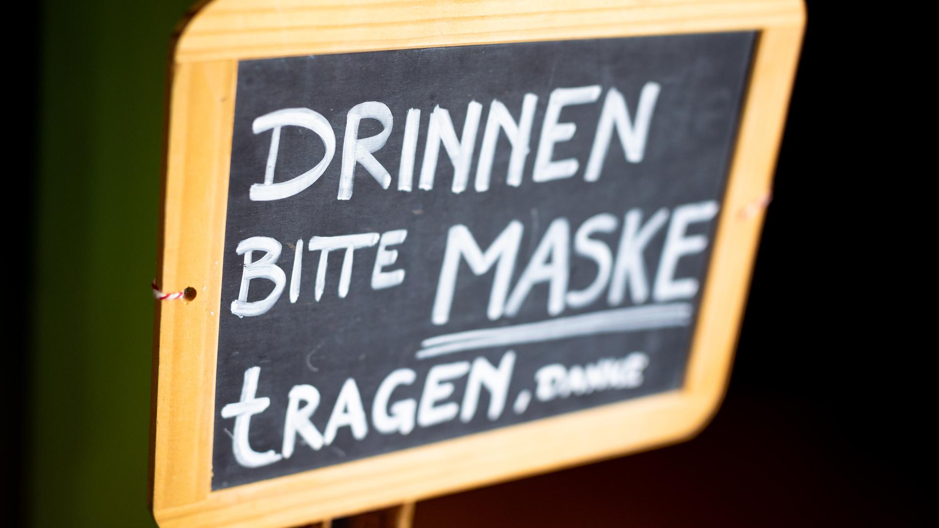 Der Schriftzug «Drinnen bitte Maske tragen, danke» ist auf dem Schild eines Restaurants zu lesen.