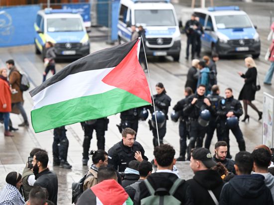 Menschen beteiligen sich an einer Pro-Palästina-Demonstration auf dem Schloßplatz. Die Kundgebung wird von einem Polizeiaufgebot begleitet. +++ dpa-Bildfunk +++