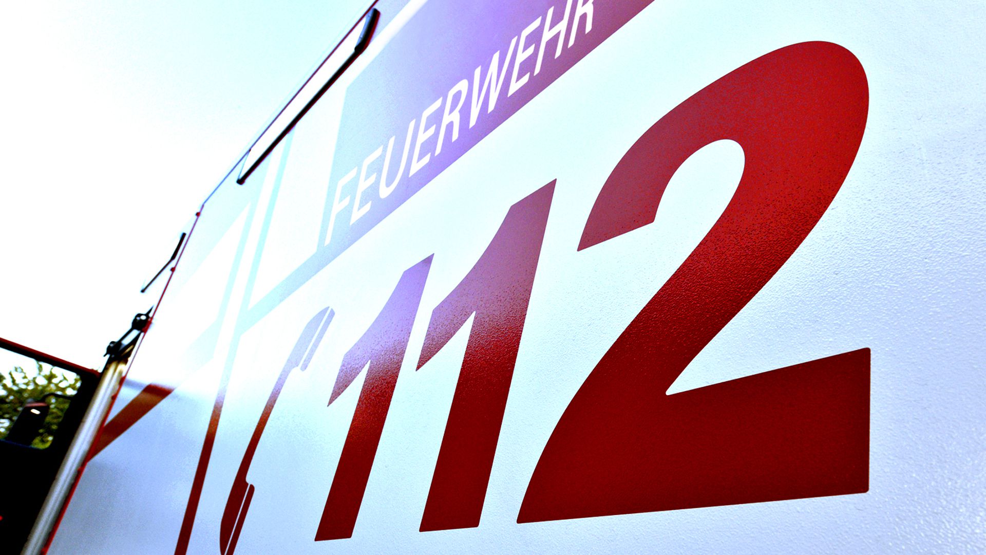 Auf einem Feuerwehrwagen steht die Notrufnummer geschrieben (Symbolbild).