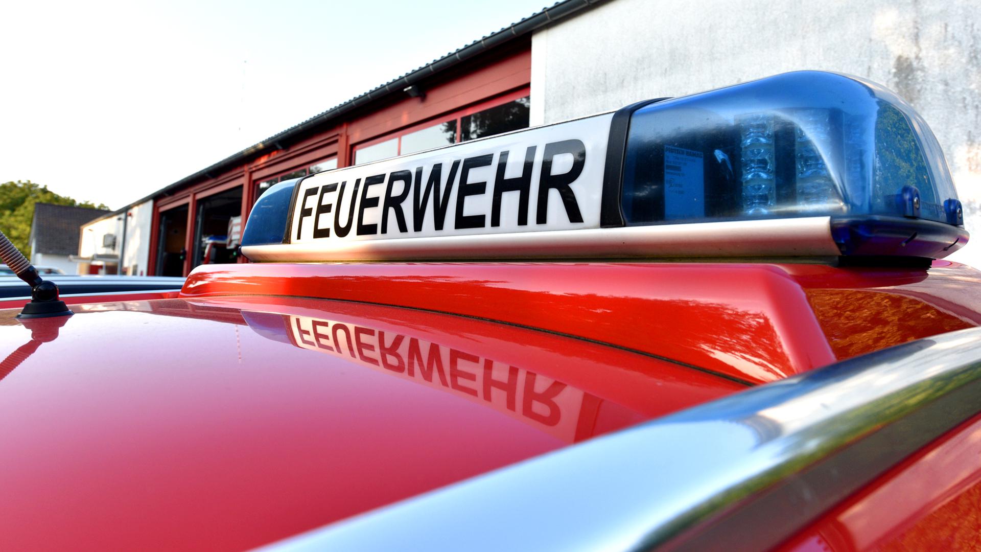 Das Blaulicht eines Feuerwehrwagens spiegelt sich (Symbolbild).