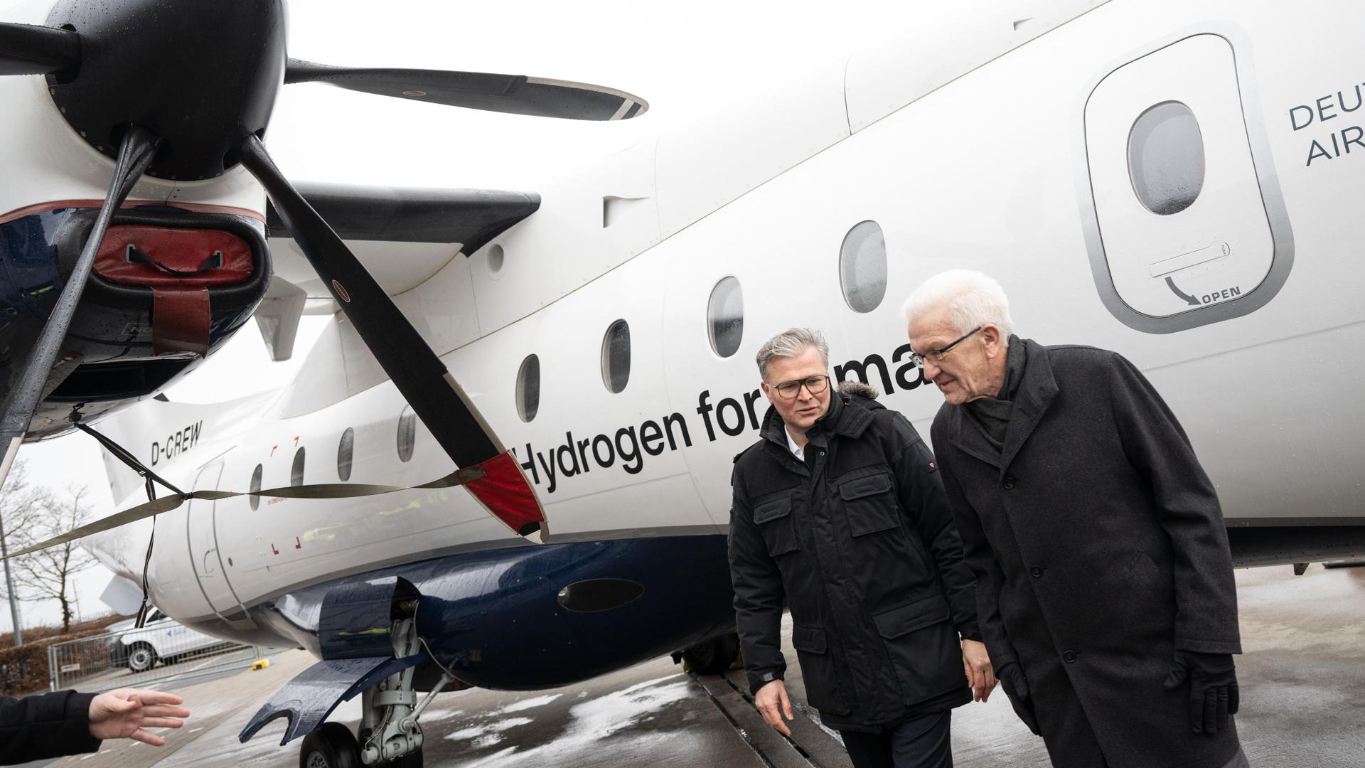 Über den Weg zum klimaneutralen Fliegen unterhalten sich Josef Kallo (l), CEO der H2Fly GmbH, und Ministerpräsident Winfried Kretschmann im Januar 2023 bei der Vorstellung des Projekts „Hydrogen Aviation Center“. 