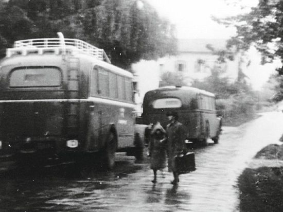 Zwei Menschen vor zwei grauen Bussen