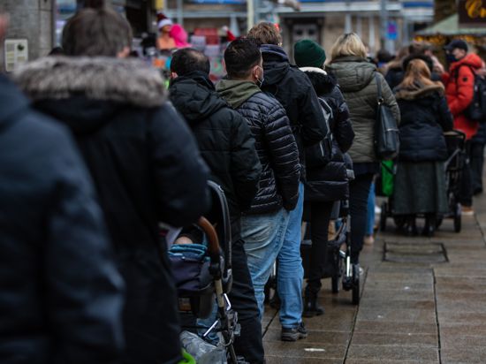 Zahlreiche Menschen warten in der Stuttgarter Innenstadt vor einem Impf-Zentrum auf ihre Corona-Impfung, die man ohne Termin dort erhalten konnte. Seit diesem Samstag gelten in Baden-Württemberg verschärfte Corona-Regeln.