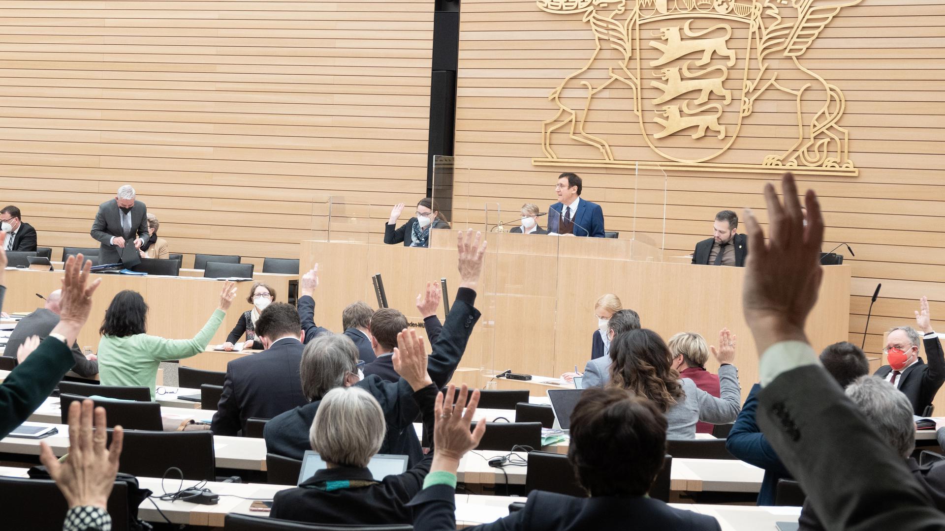 Abgeordnete heben im Plenarsaal des Landtags von Baden-Württemberg die Hände und stimmen den Haushalt für das Jahr 2022 ab. +++ dpa-Bildfunk +++