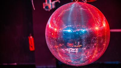 Die farbig beleuchtete Discokugel dreht sich über der Tanzfläche in der geschlossenen Diskothek Zenit. 