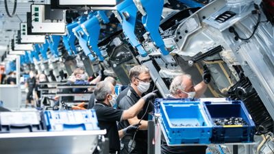 Mitarbeitende von Mercedes-Benz arbeiten im Werk „Factory 56“ an einer S-Klasse.