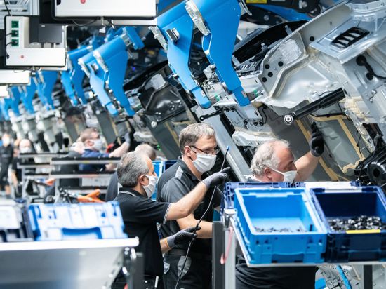 Mitarbeitende von Mercedes-Benz arbeiten im Werk „Factory 56“ an einer S-Klasse.