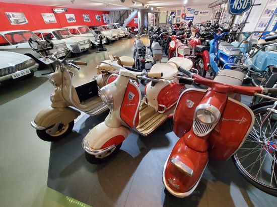 Motorräder, Autos, Fahrräder in einer Ausstellungshalle