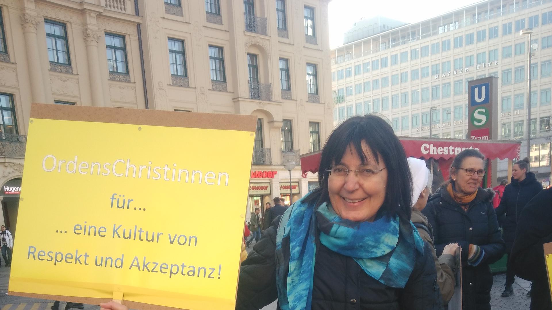 Susanne Schneider hält ein Plakat hoch: „OrdensChristinnen für eine Kultur von Respekt und Akzeptanz!”